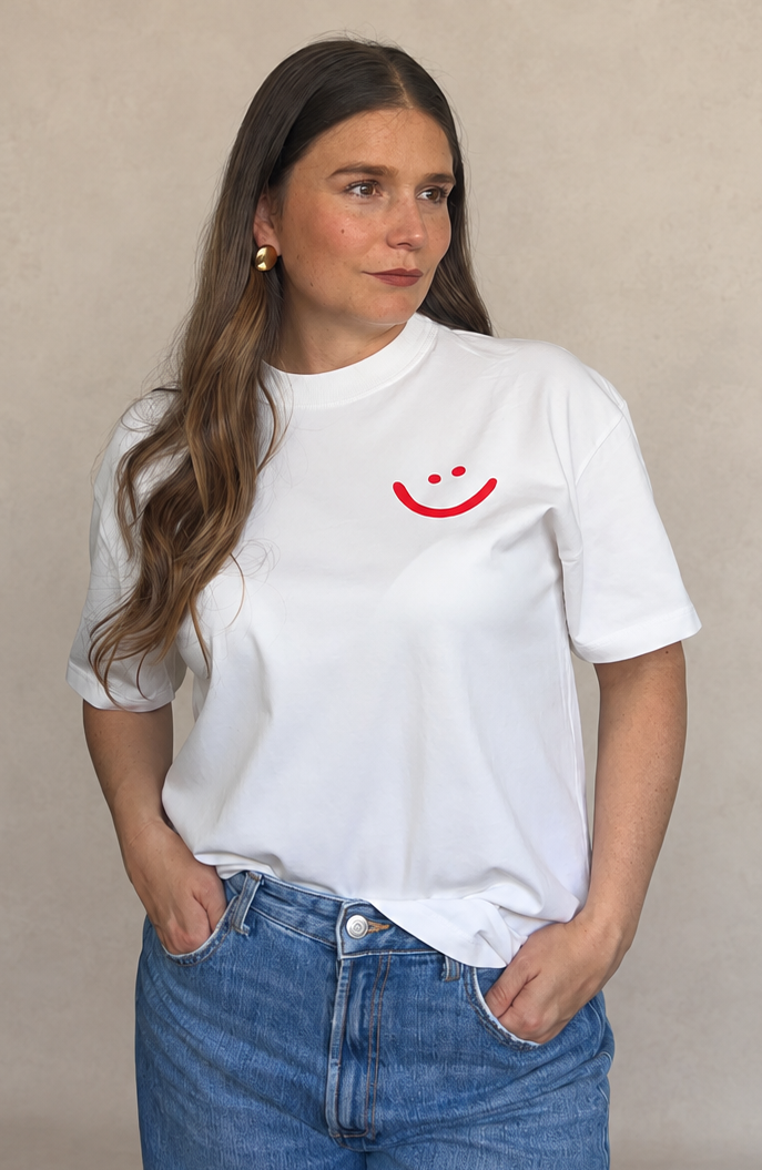 Camiseta gráfica blanca con sonrisa roja